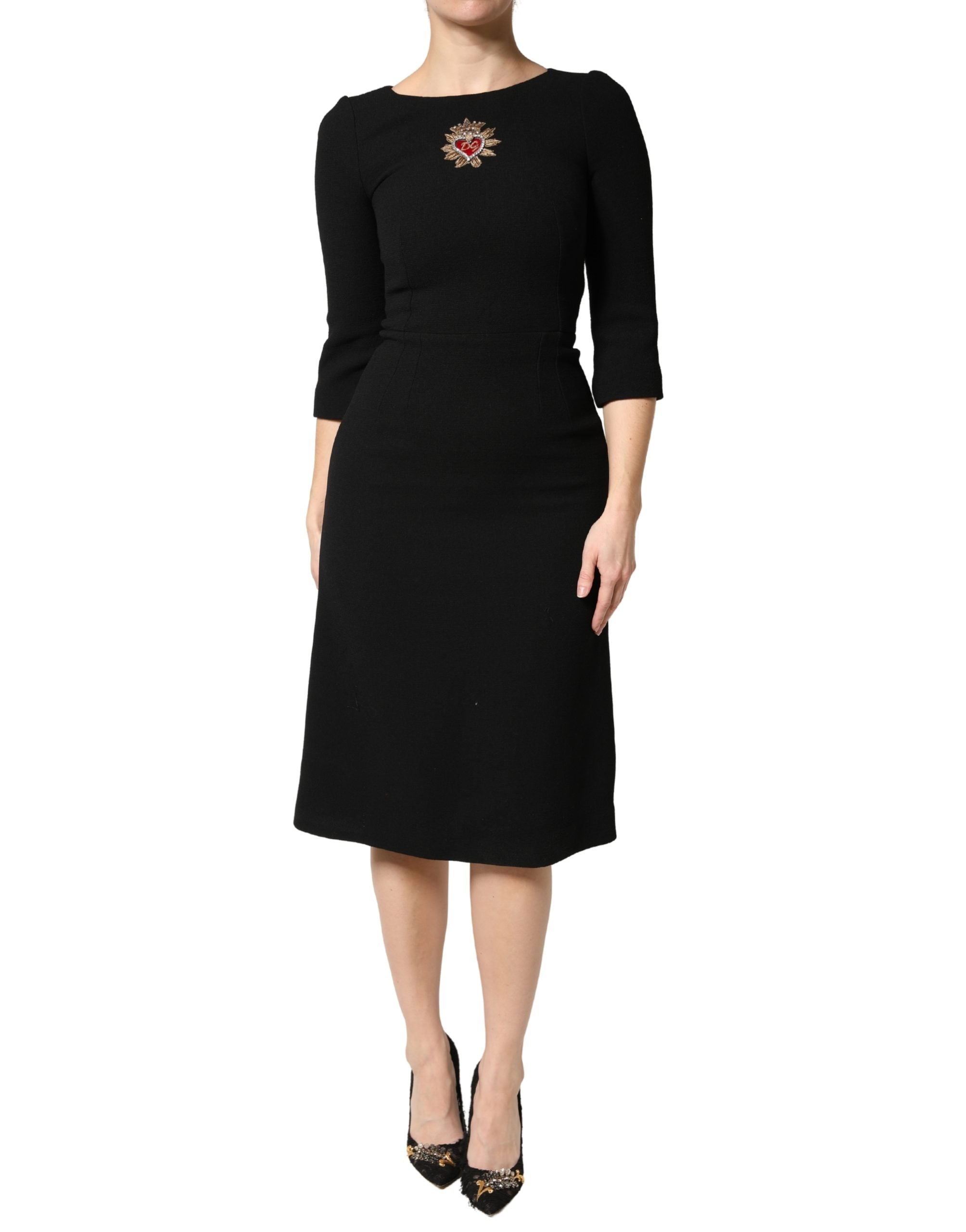 Robe midi en laine noire Dolce & Gabbana avec patch de cœur sacré, design élégant et détails sophistiqués.