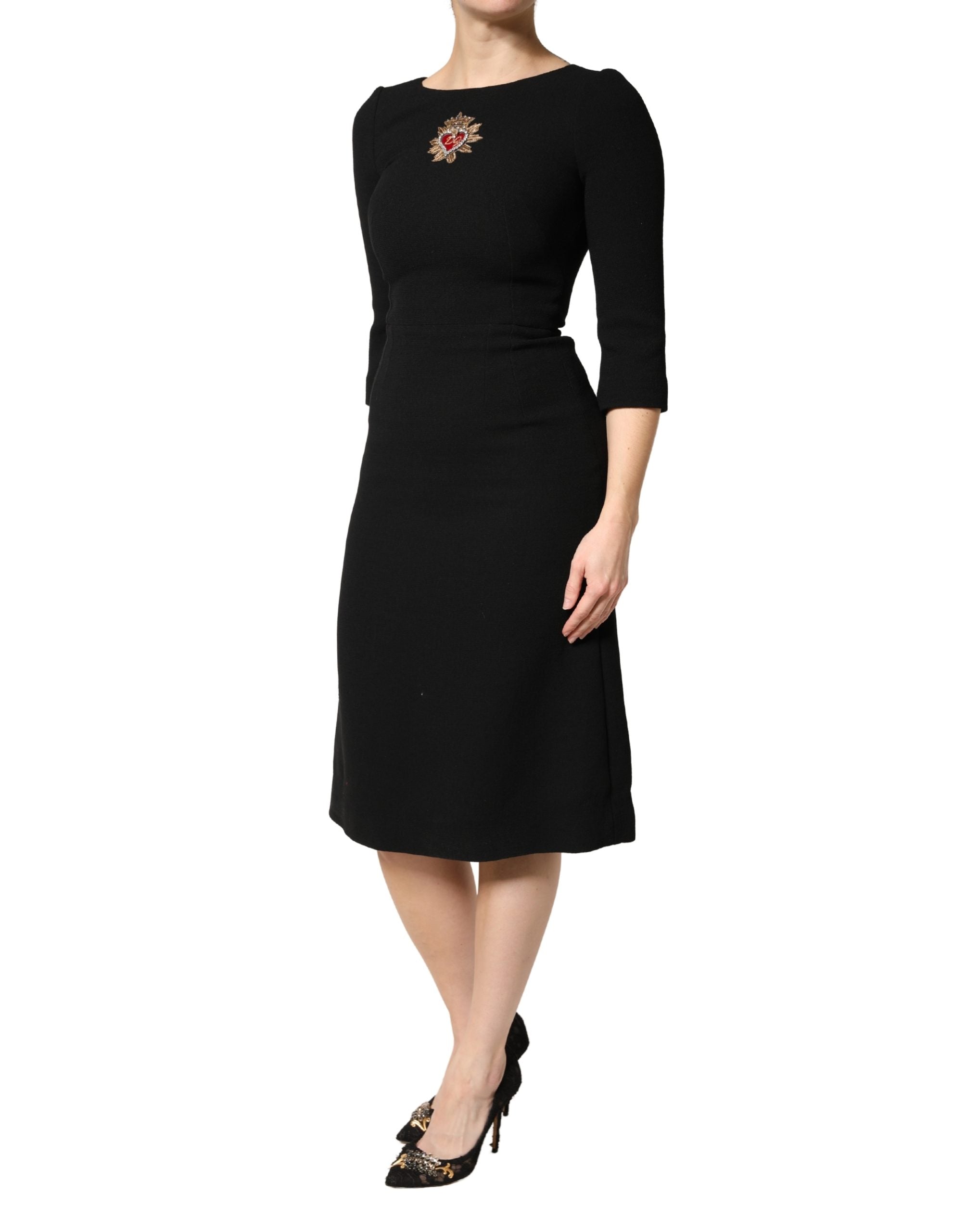Robe midi en laine noire Dolce & Gabbana avec patch cœur sacré, détail élégant et tissu chaud, style sophistiqué et moderne.