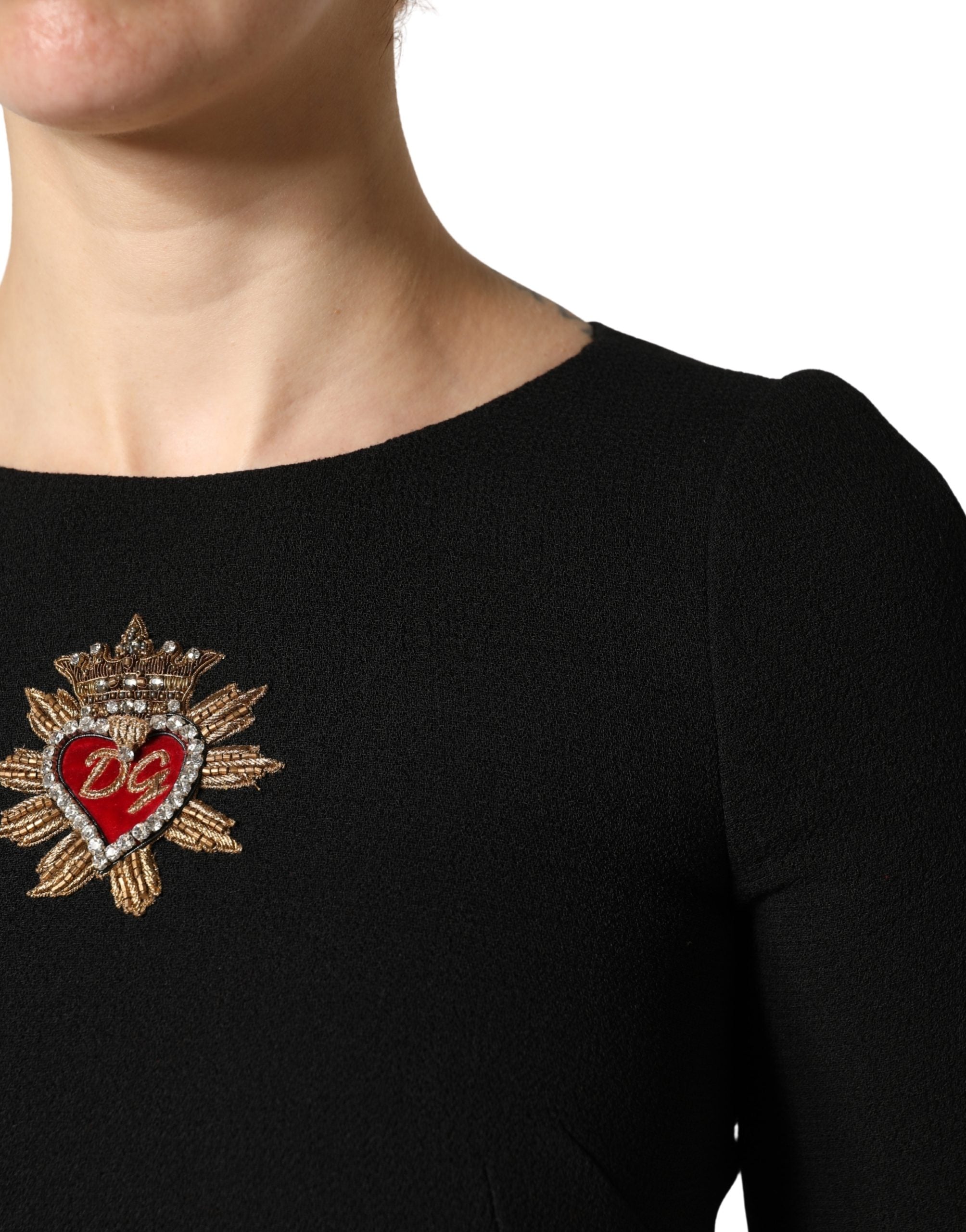 Robe midi en laine noire Dolce & Gabbana avec patch cœur sacré, détail élégant et design sophistiqué.