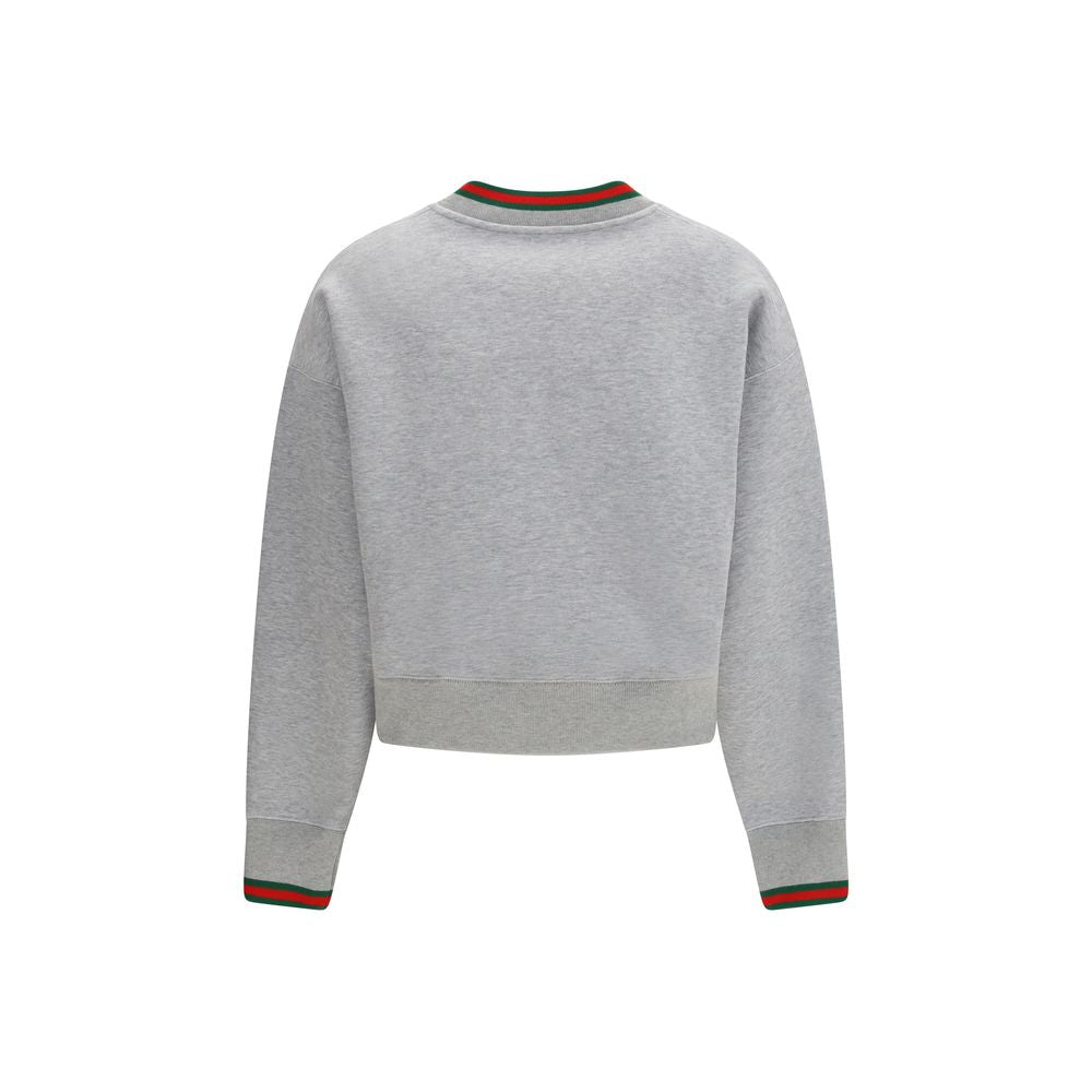 Sweat-shirt gris en coton de Gucci avec logo signature, porté, montrant le design décontracté et le tissu doux.