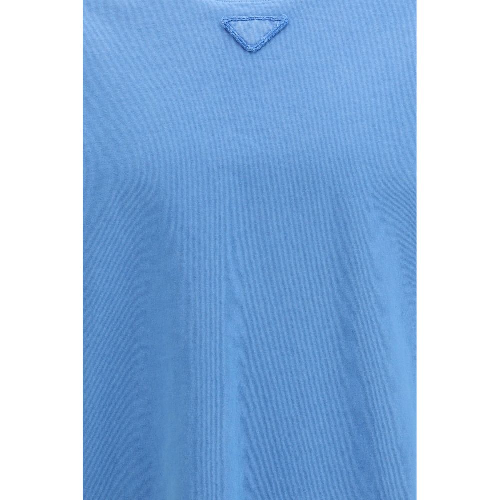 T-shirt en coton bleu Prada, coupe classique avec logo Prada visible sur la poitrine, porté sur un mannequin.