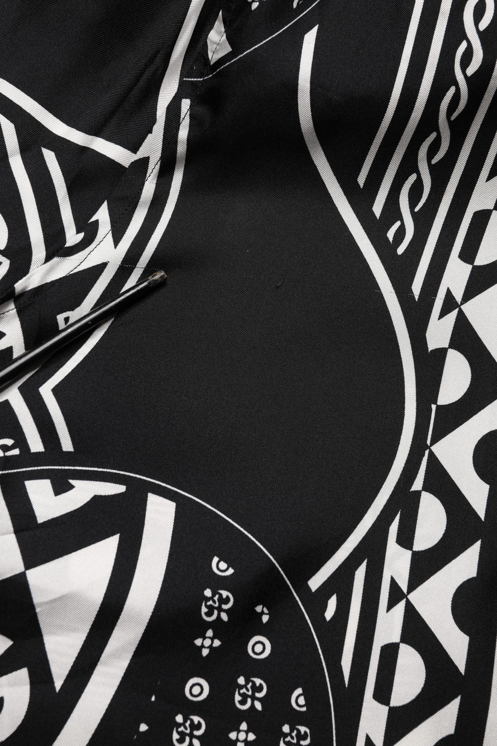 Chemise Dolce & Gabbana en soie noire à logo imprimé, manches courtes et style élégant visible sur l'image.