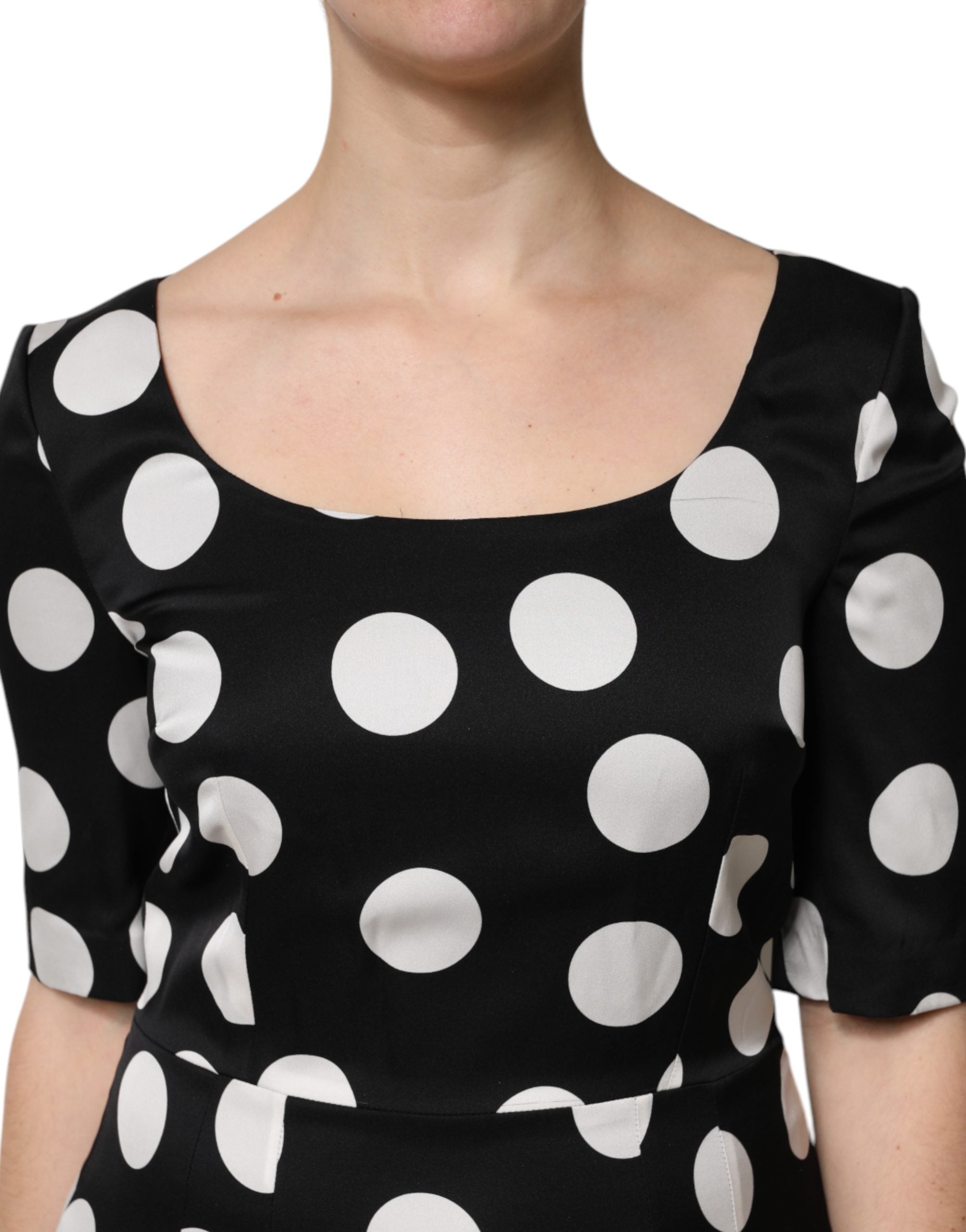 Robe midi en soie noire et blanche à pois Dolce & Gabbana, coupe ajustée et élégante, portée sur un mannequin.