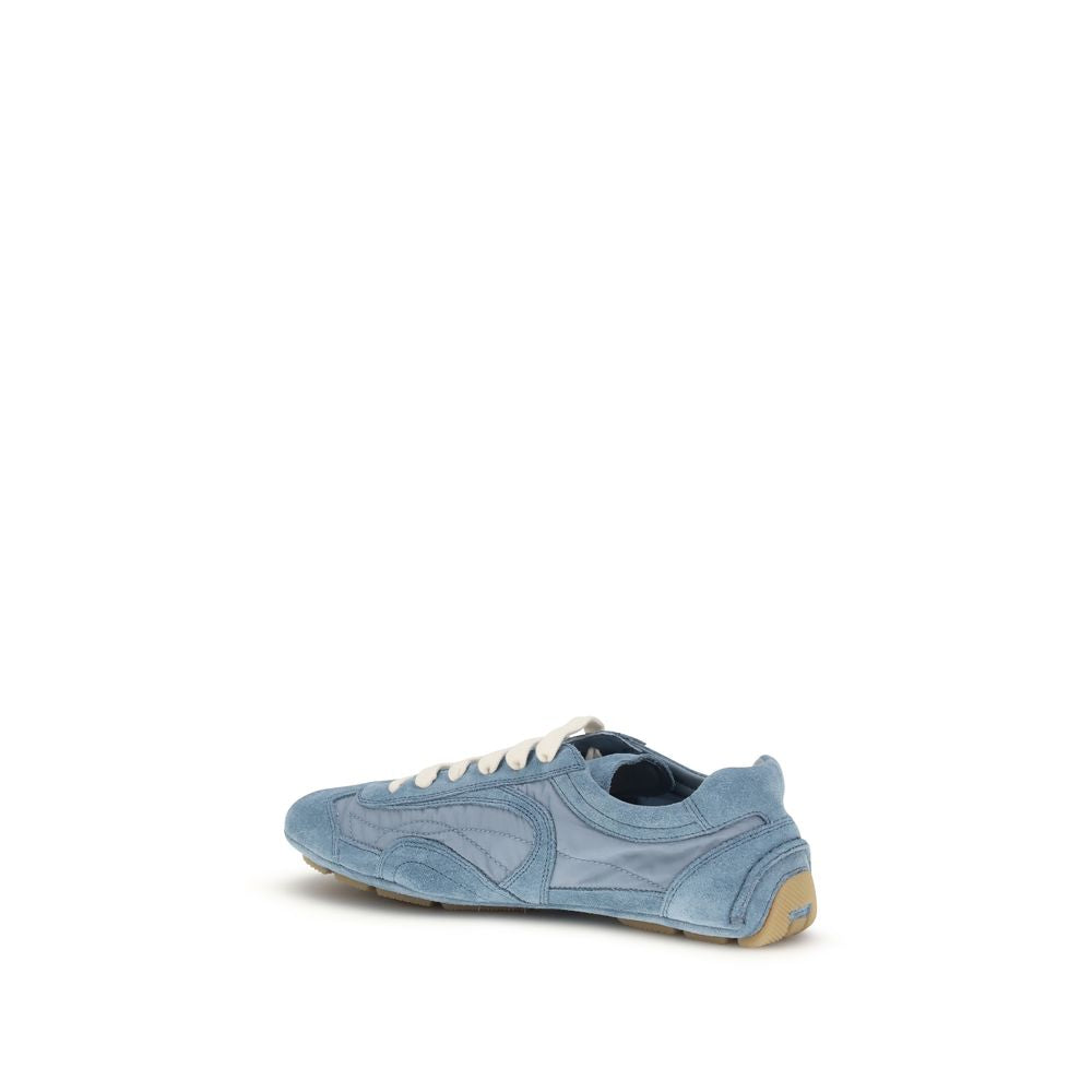 Baskets Prada en cuir d'agneau bleu, style athlétique, avec détails modernes et logo Prada visibles.