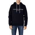 Sweat à capuche en coton bleu Tommy Hilfiger avec logo sur la poitrine, porté sur un mannequin.