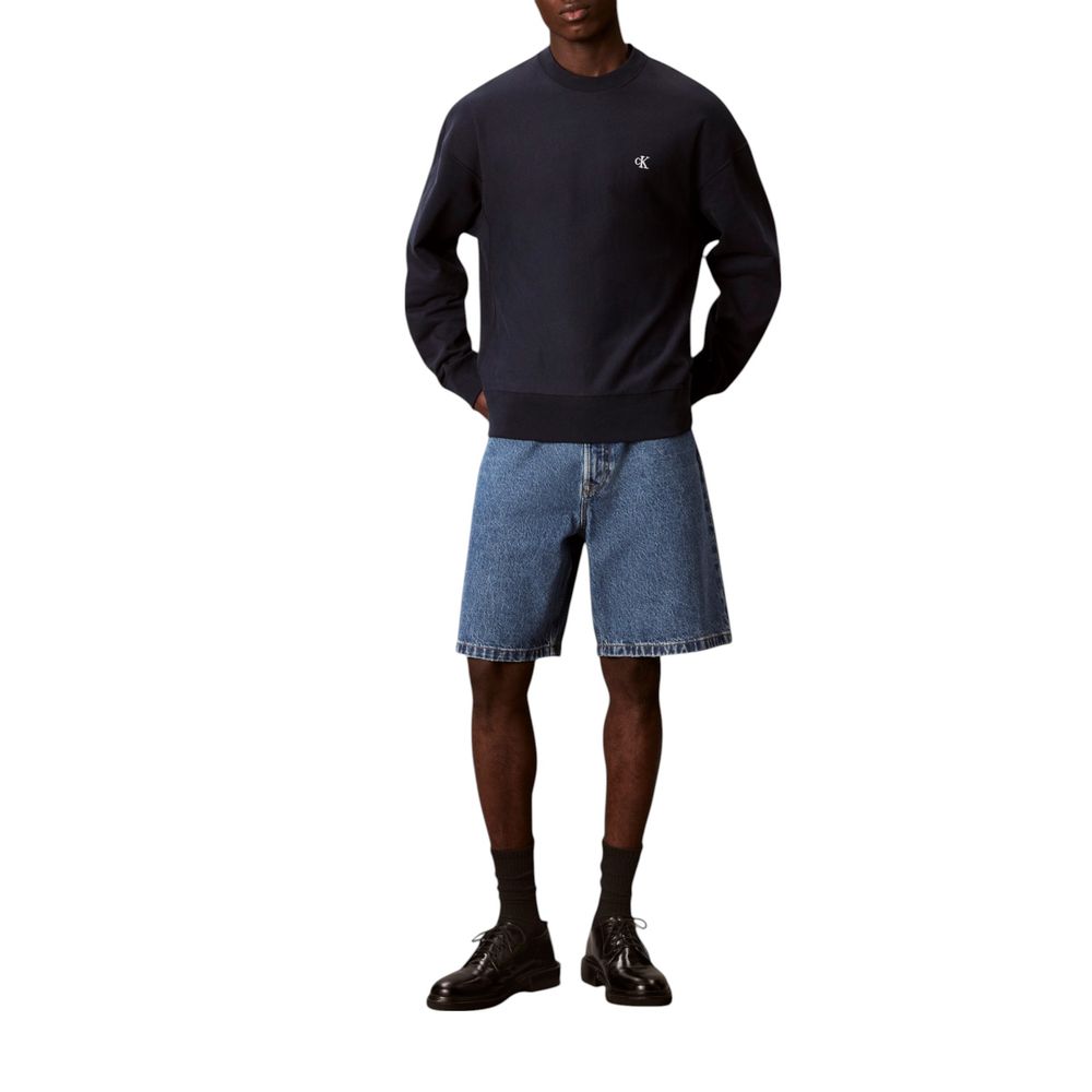 Sweat-shirt bleu en coton de Calvin Klein Jeans, coupe classique, avec logo discret sur la poitrine, porté sur un mannequin.