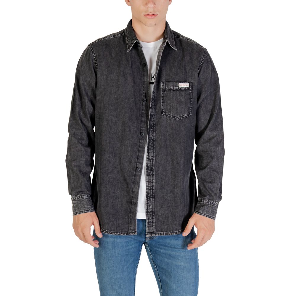 Chemise en jean noire Calvin Klein Jeans, coupe classique, boutons en métal et poches poitrine, portée décontractée.