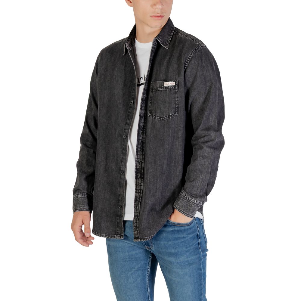 Chemise en jean noire de Calvin Klein Jeans, coupe classique, avec boutons et col, portée sur un mannequin.
