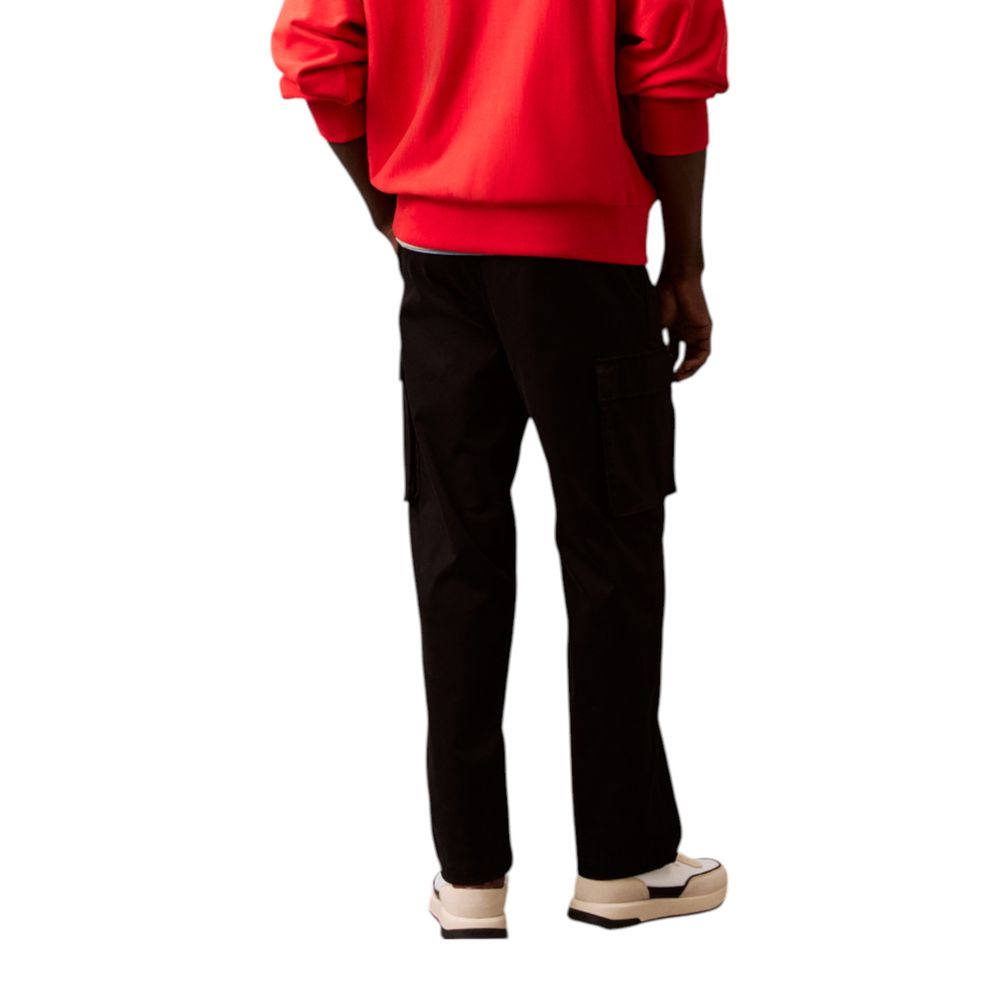 Pantalon cargo en coton noir de Calvin Klein Jeans, style décontracté avec poches latérales, visible sur l'image.