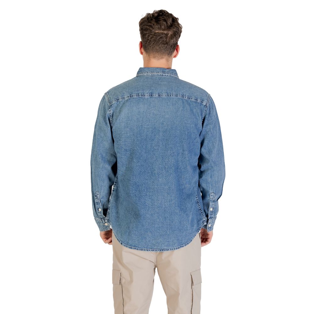 Chemise en denim bleu Calvin Klein Jeans, coupe classique, avec col et boutons, portée sur un mannequin.