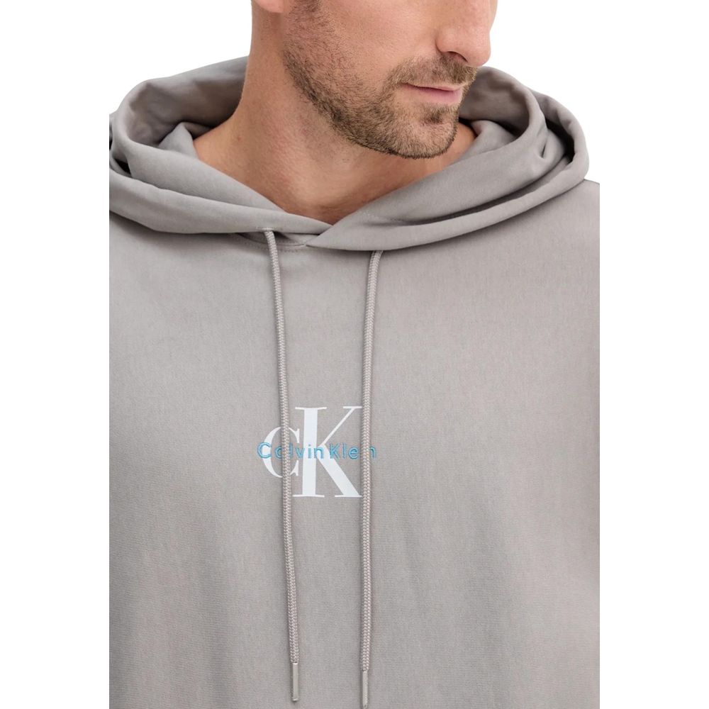 Sweat à capuche en coton gris de Calvin Klein Jeans, douceur et style décontracté, avec logo discret sur la poitrine.