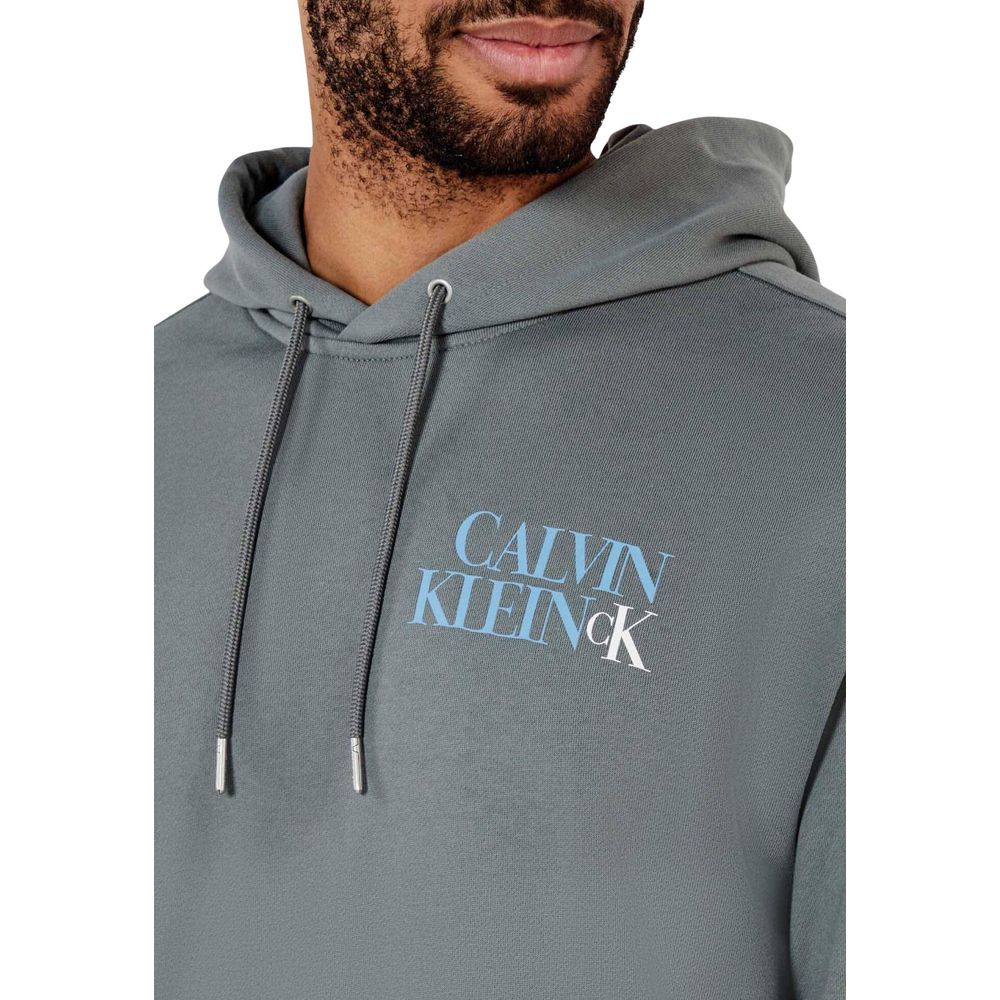Sweat à capuche gris en coton de Calvin Klein Jeans, logo visible, porté de face avec détails du tissu.