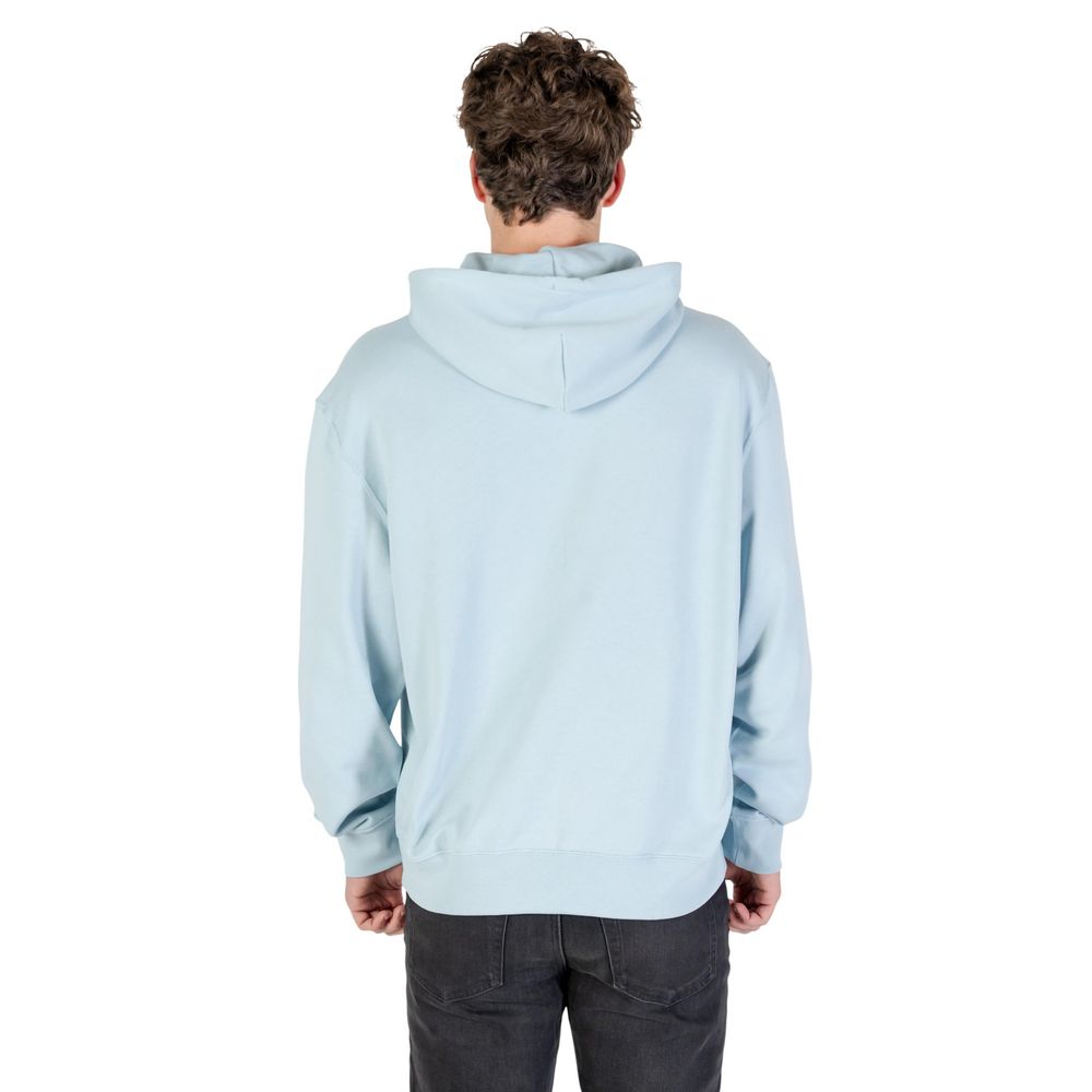Sweat à capuche en coton bleu de Calvin Klein Jeans, avec logo discret, porté par un mannequin.