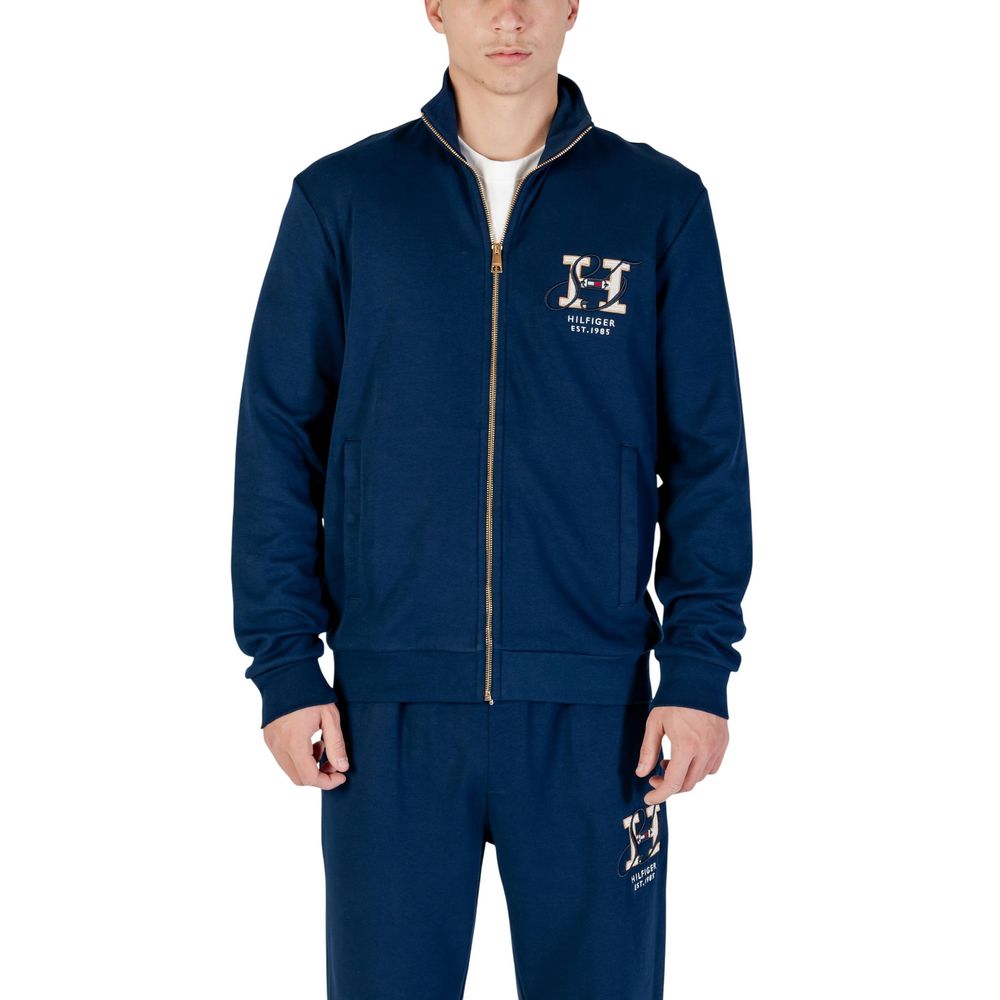 Sweatshirt en coton recyclé bleu de Tommy Hilfiger, avec logo discret sur la poitrine, porté dans un style décontracté.