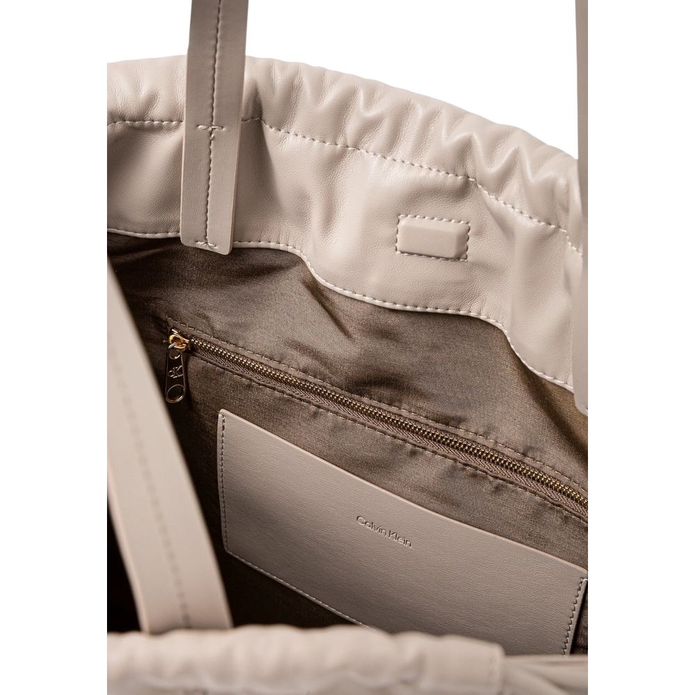 Sac à main beige en polyéthylène de Calvin Klein, avec poignées et design épuré visible sur l'image.