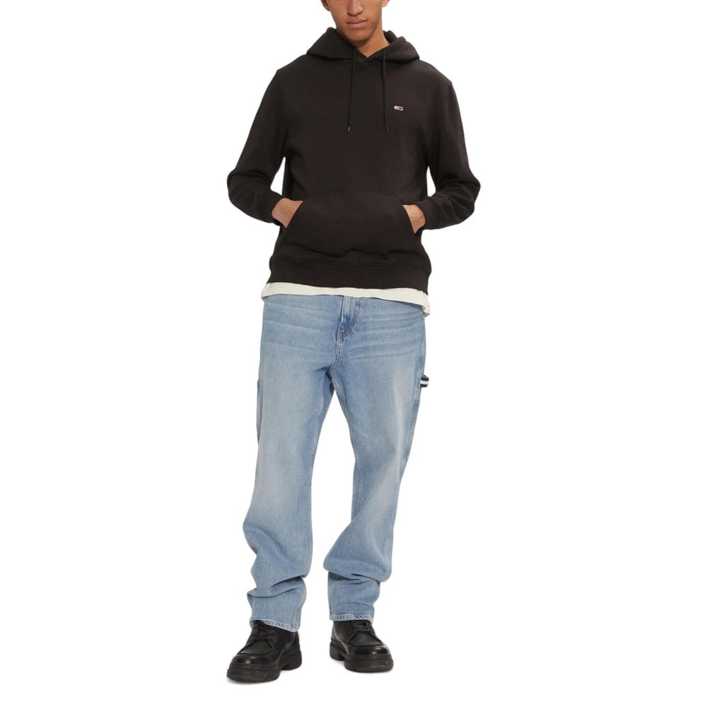 Hoodie noir en coton Tommy Hilfiger Jeans, avec logo sur la poitrine et capuche, porté sur un mannequin.