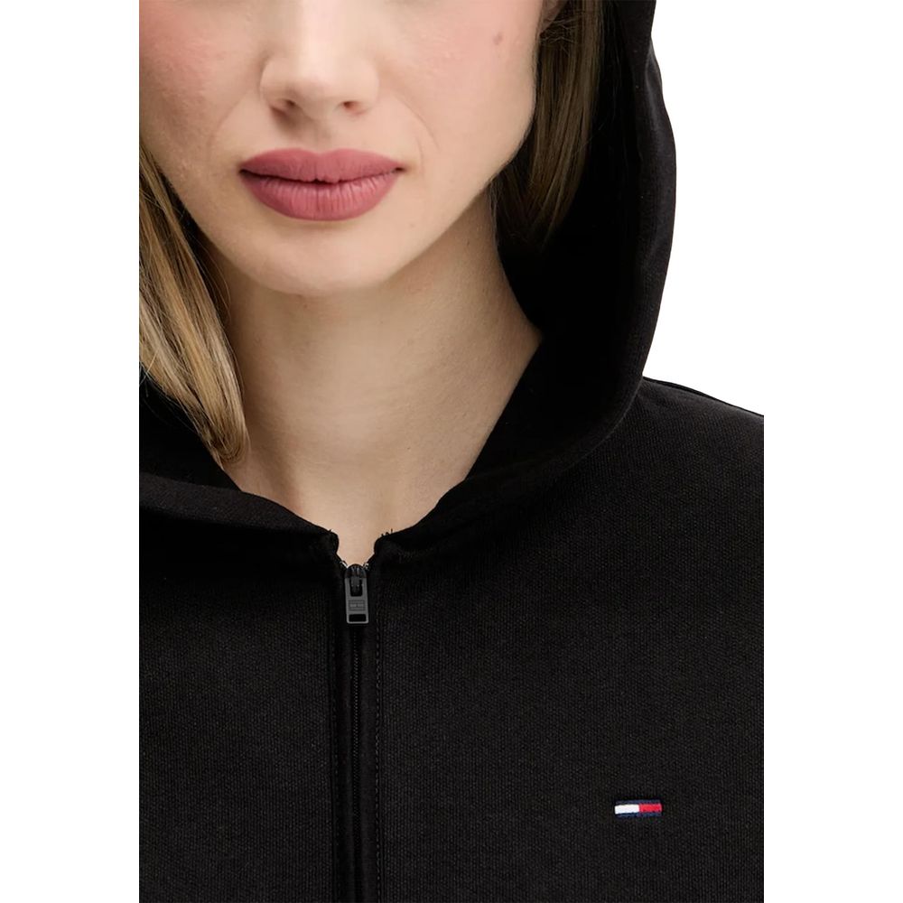 Hoodie Tommy Hilfiger Jeans noir en coton recyclé, avec logo et capuche, porté sur un mannequin.