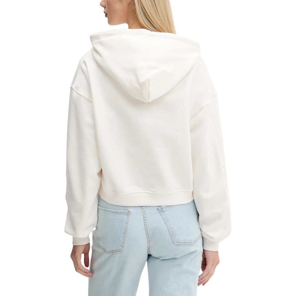 Hoodie Tommy Hilfiger Jeans en coton recyclé de couleur crème, avec logo et détails modernes, porté sur un mannequin.