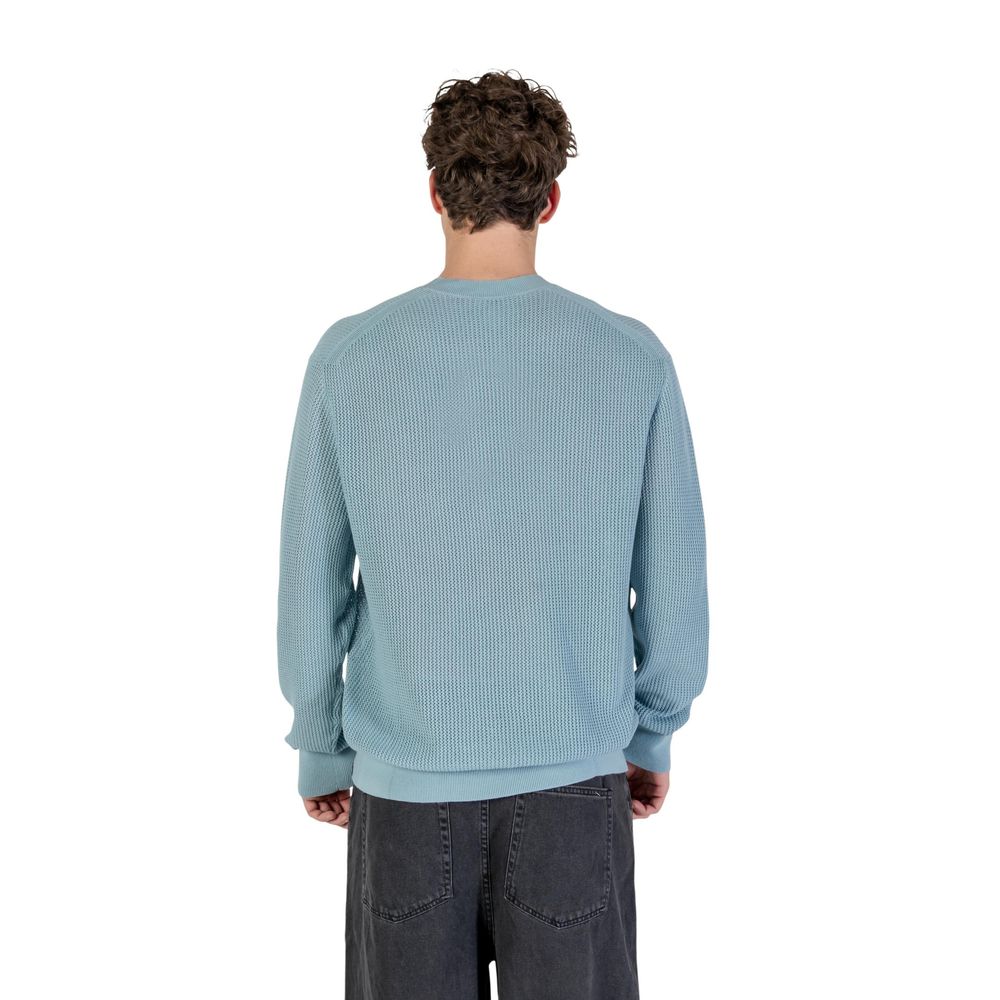 Sweatshirt en coton bleu de Calvin Klein Jeans, coupe décontractée, logo discret sur la poitrine, porté sur un mannequin.