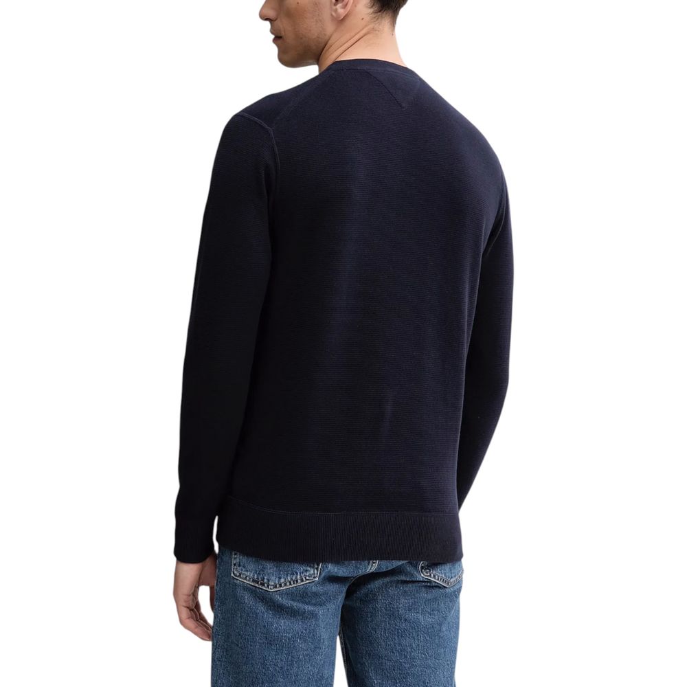 Sweat-shirt bleu en coton biologique de Tommy Hilfiger, à capuche avec logo discret, porté sur un mannequin.
