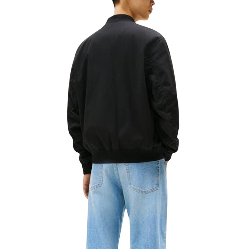 Jean bomber noir Tommy Hilfiger Jeans en coton recyclé, vue de face montrant la coupe décontractée et les détails de style.