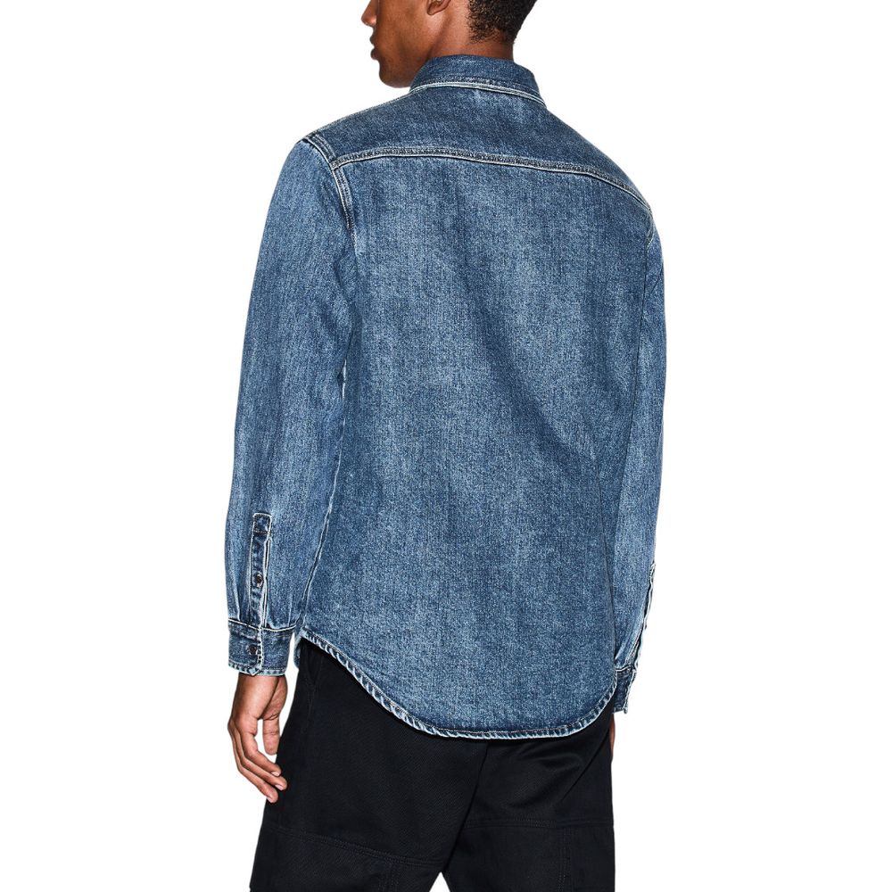 Chemise en jean bleu Armani Exchange, coupe classique avec boutons et col, portée décontractée.