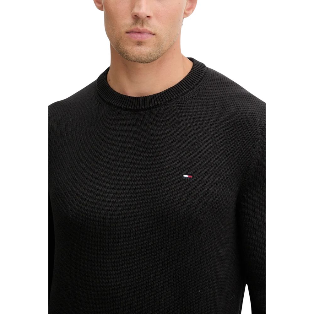 Sweatshirt Tommy Hilfiger Jeans en coton biologique noir avec logo sur la poitrine, porté par un mannequin.