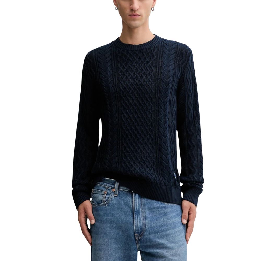 Jean Tommy Hilfiger en coton recyclé bleu avec sweat-shirt assorti, visible en gros plan sur fond neutre.