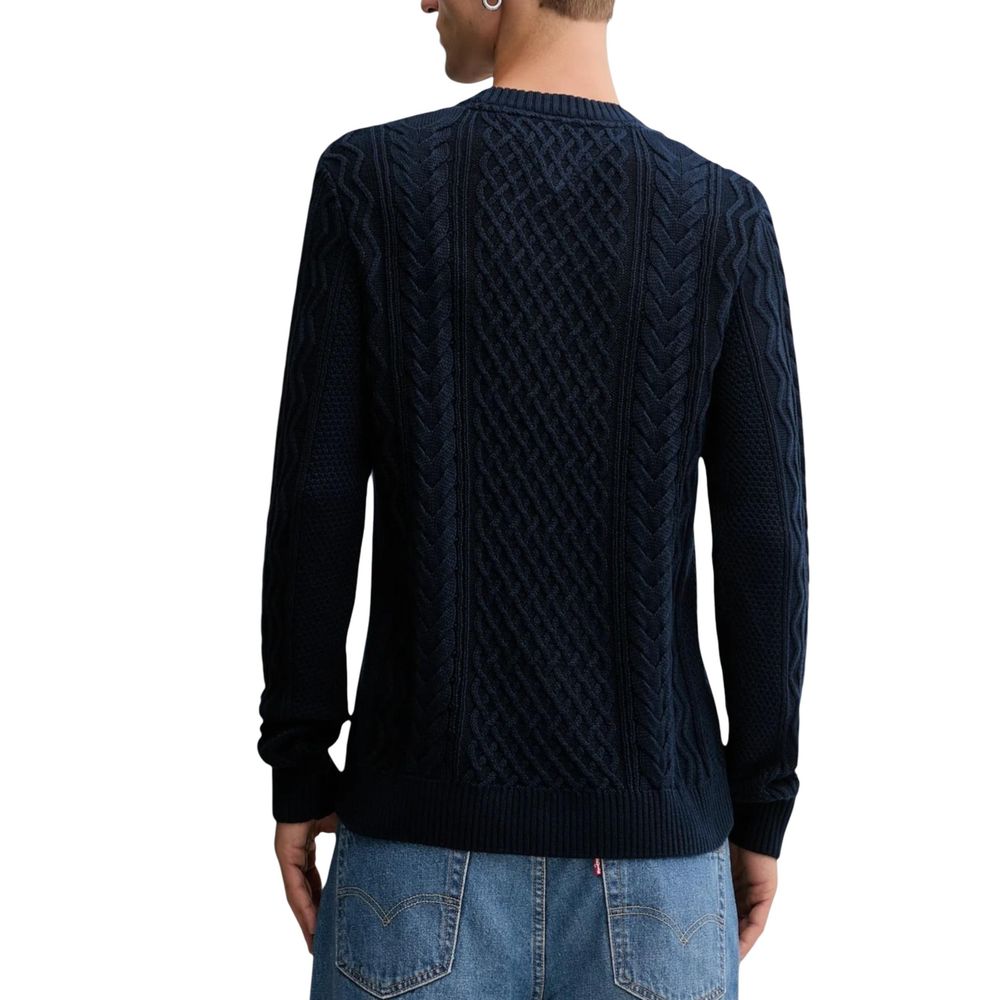 Jeans Tommy Hilfiger en coton recyclé, coupe classique, couleur bleue, porté avec un sweatshirt assorti.