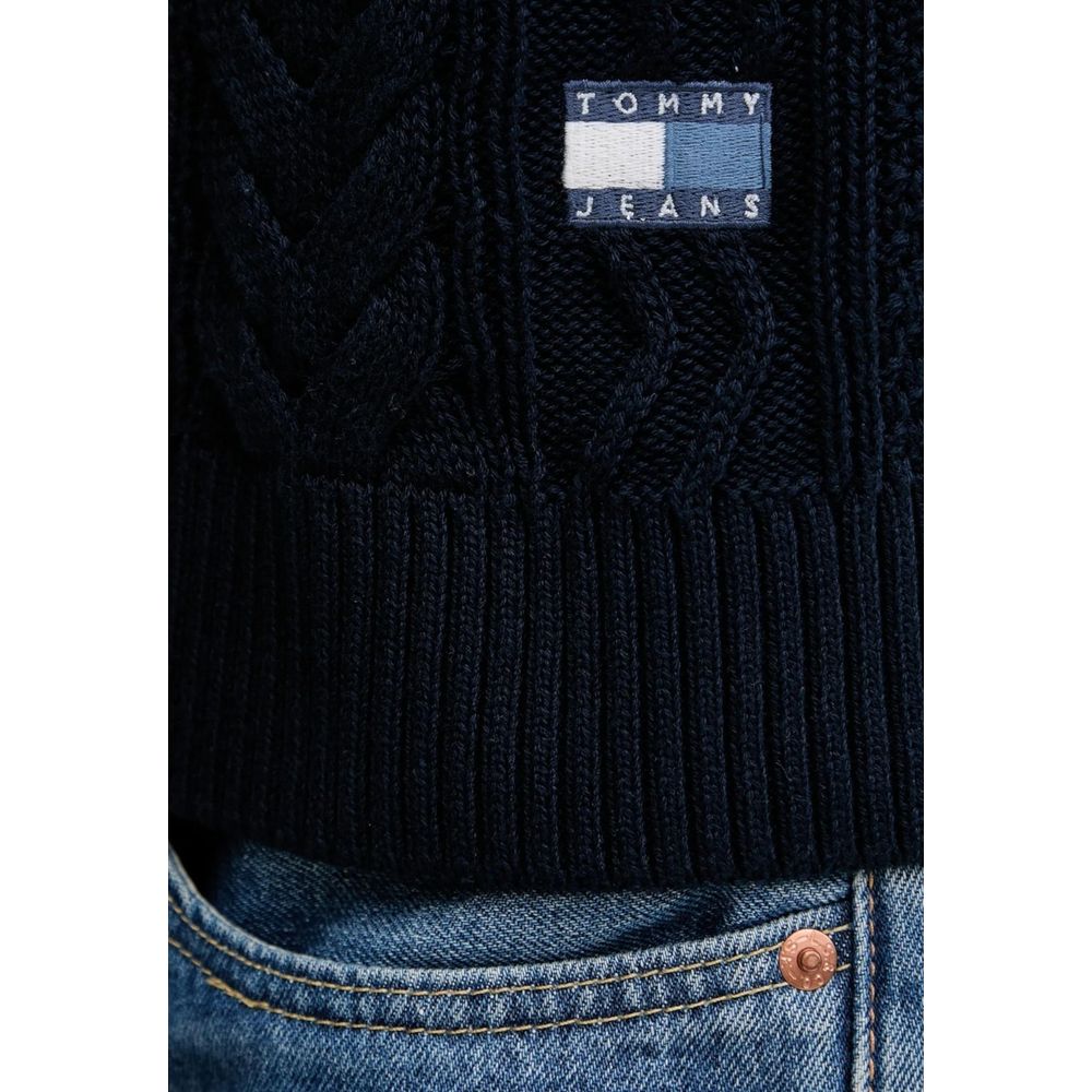 Jean Tommy Hilfiger en coton recyclé bleu porté avec un sweat-shirt assorti, visible en gros plan.
