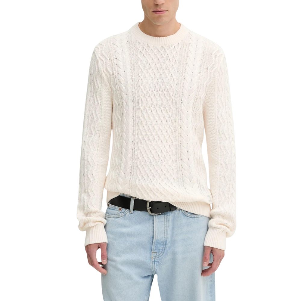 Pull à manches longues Tommy Hilfiger Jeans en coton recyclé de couleur crème, coupe décontractée, visible sur l'image.