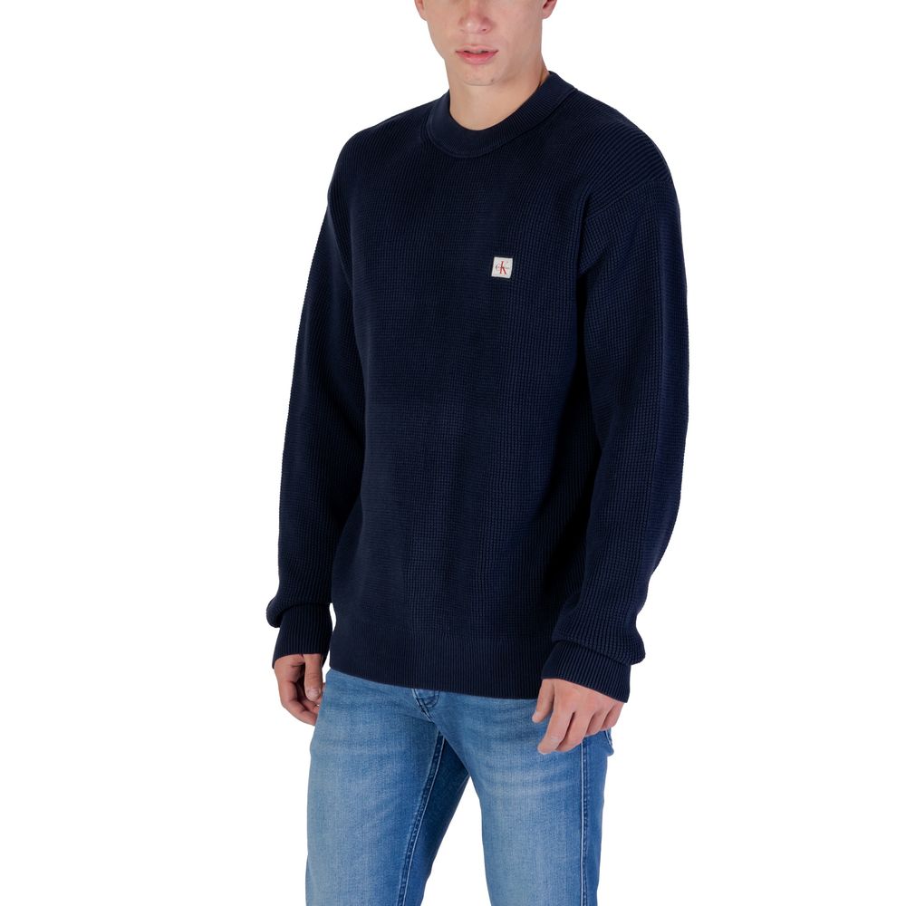 Sweat-shirt en coton bleu de Calvin Klein Jeans, avec logo discret sur la poitrine, porté dans un style décontracté.