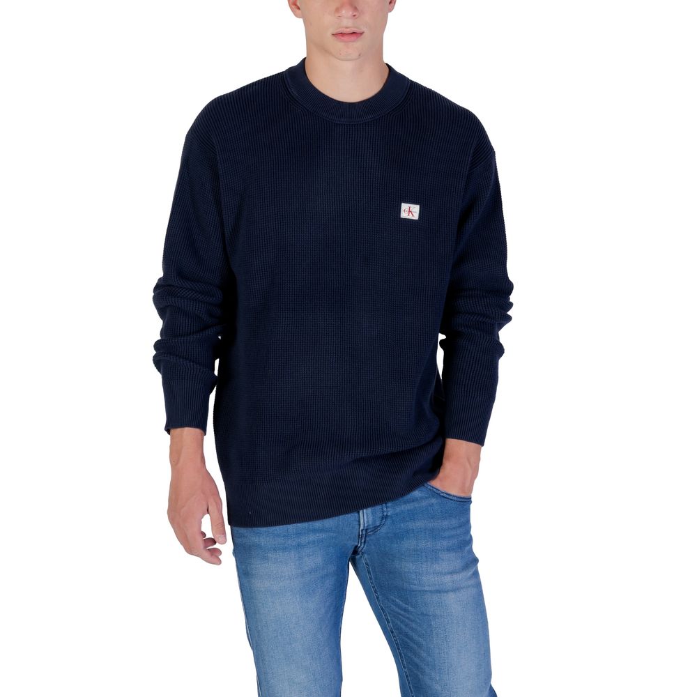 Sweatshirt en coton bleu de Calvin Klein Jeans, style décontracté avec logo discret, porté sur un mannequin.