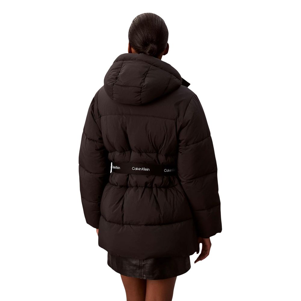 Manteau noir en polyamide de Calvin Klein Jeans, coupe élégante, avec capuche et fermeture éclair, porté en extérieur.