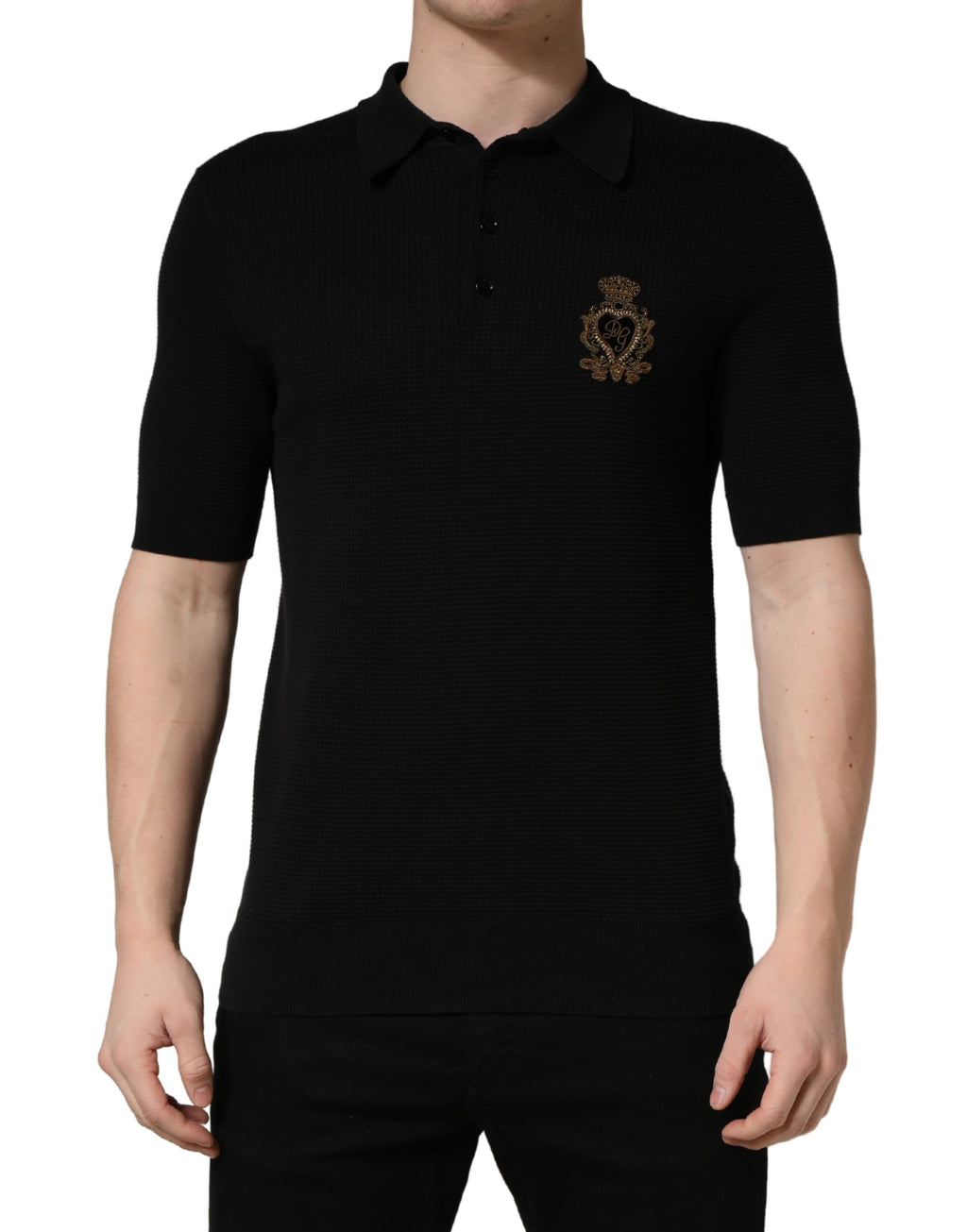 Polo en soie noir Dolce & Gabbana avec écusson héralique brodé, détails élégants et logo visible sur la poitrine.