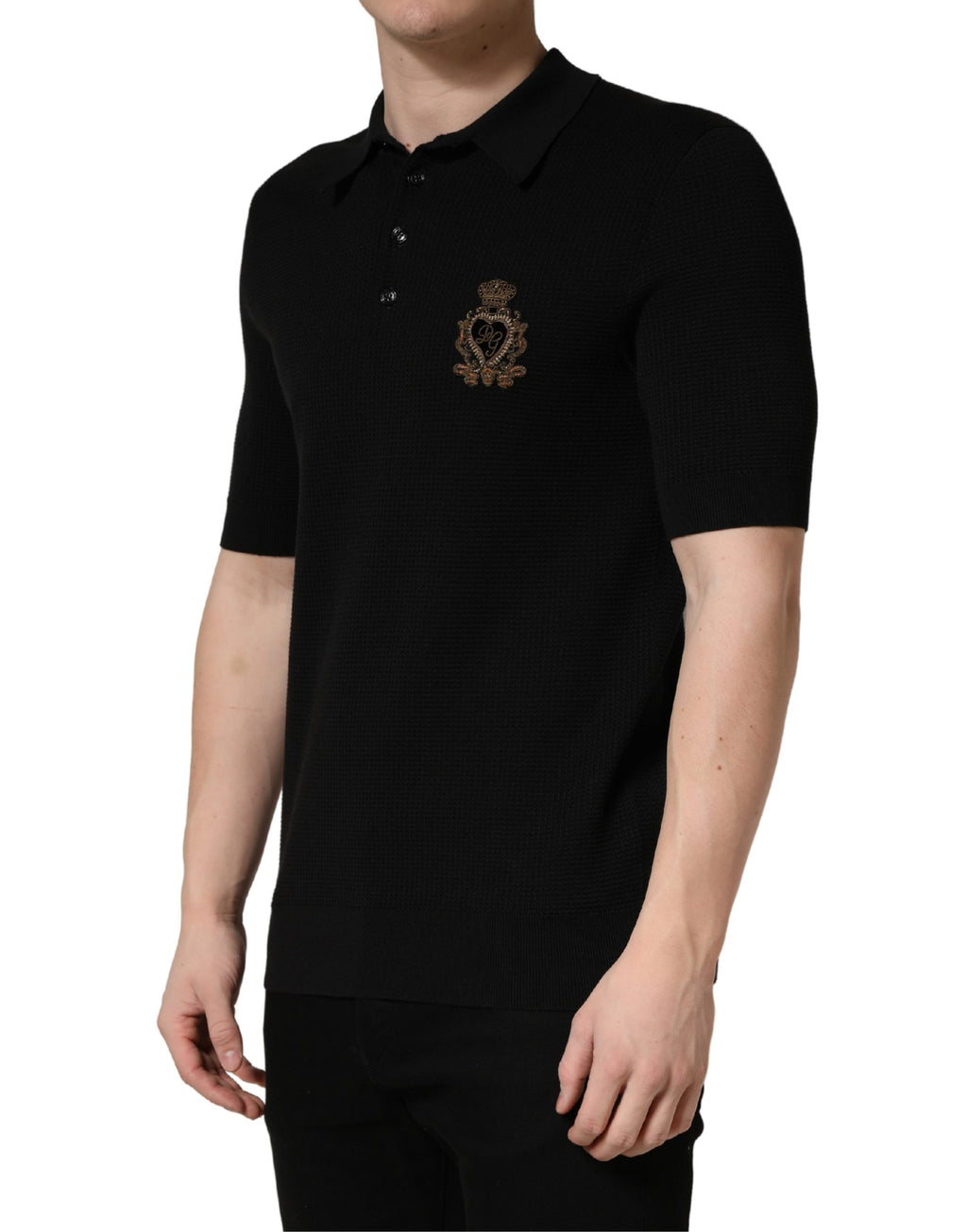 Polo en soie noir Dolce & Gabbana avec écusson héraldique brodé sur le devant, style élégant et sophistiqué.