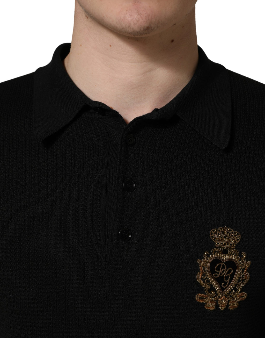 Polo en soie noir Dolce & Gabbana avec écusson héraldique brodé, élégant et classique.