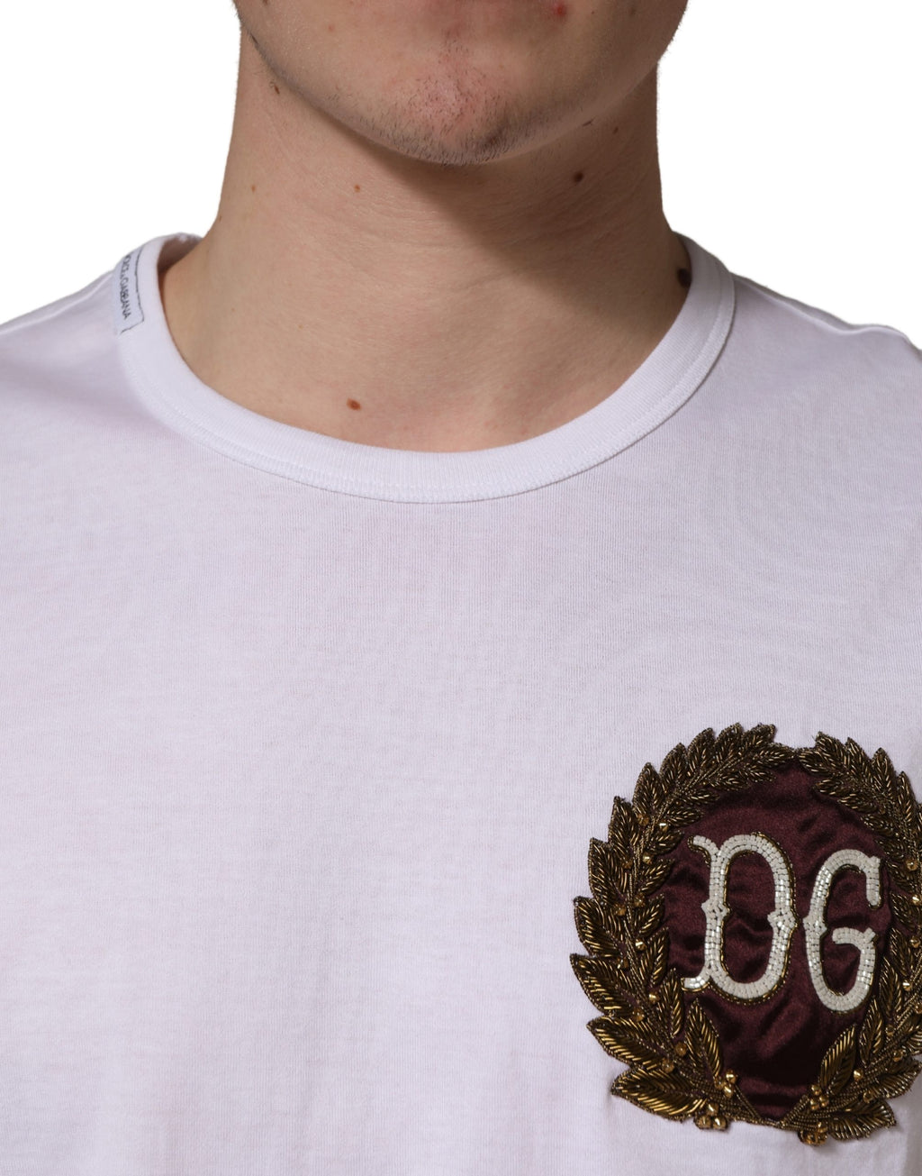 T-shirt blanc Dolce & Gabbana avec broderie de feuilles DG, col rond, style décontracté, tissu coton visible.
