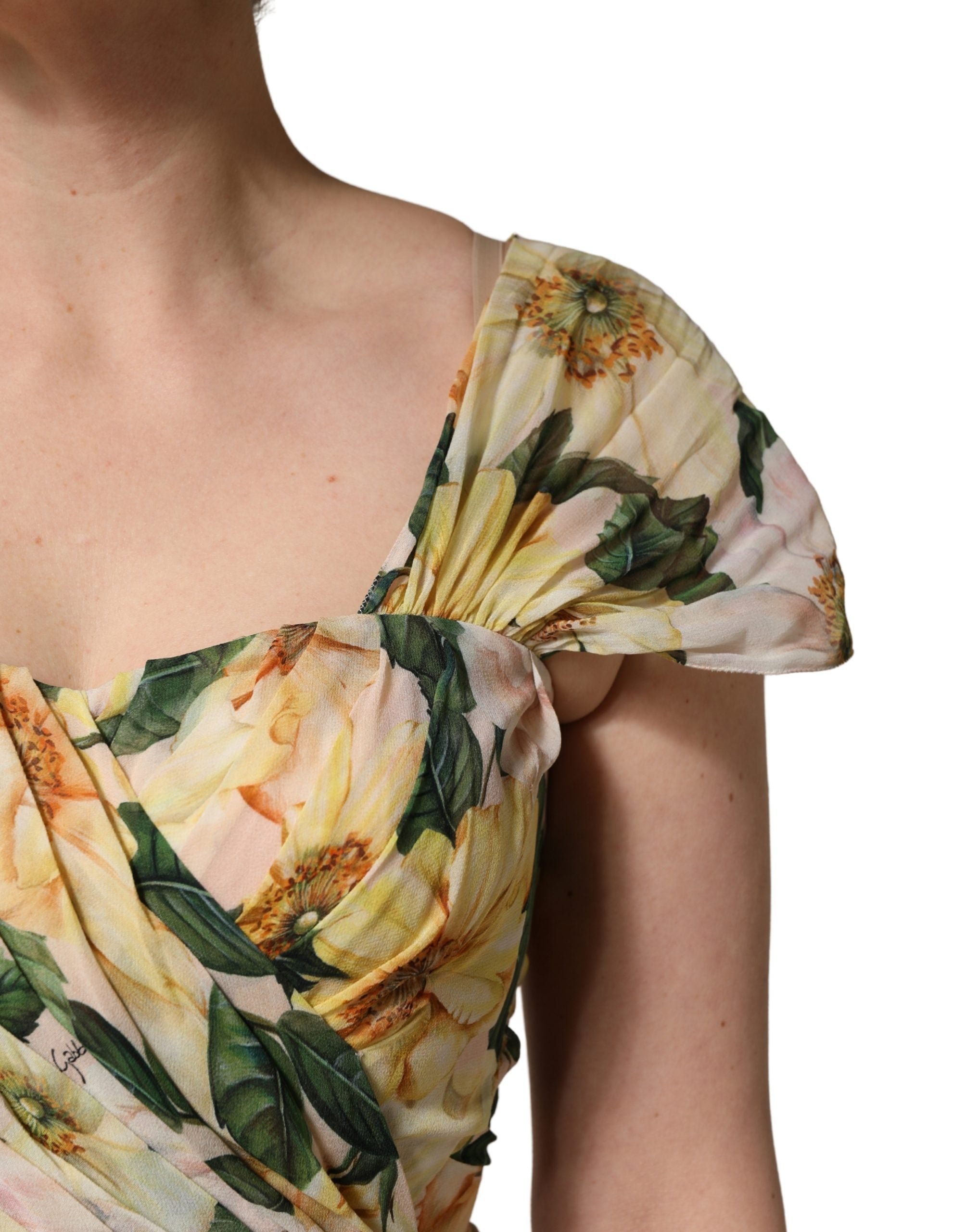 Robe longue plissée en soie jaune à motif floral Dolce & Gabbana, élégante et fluide, portée avec décolleté en V.