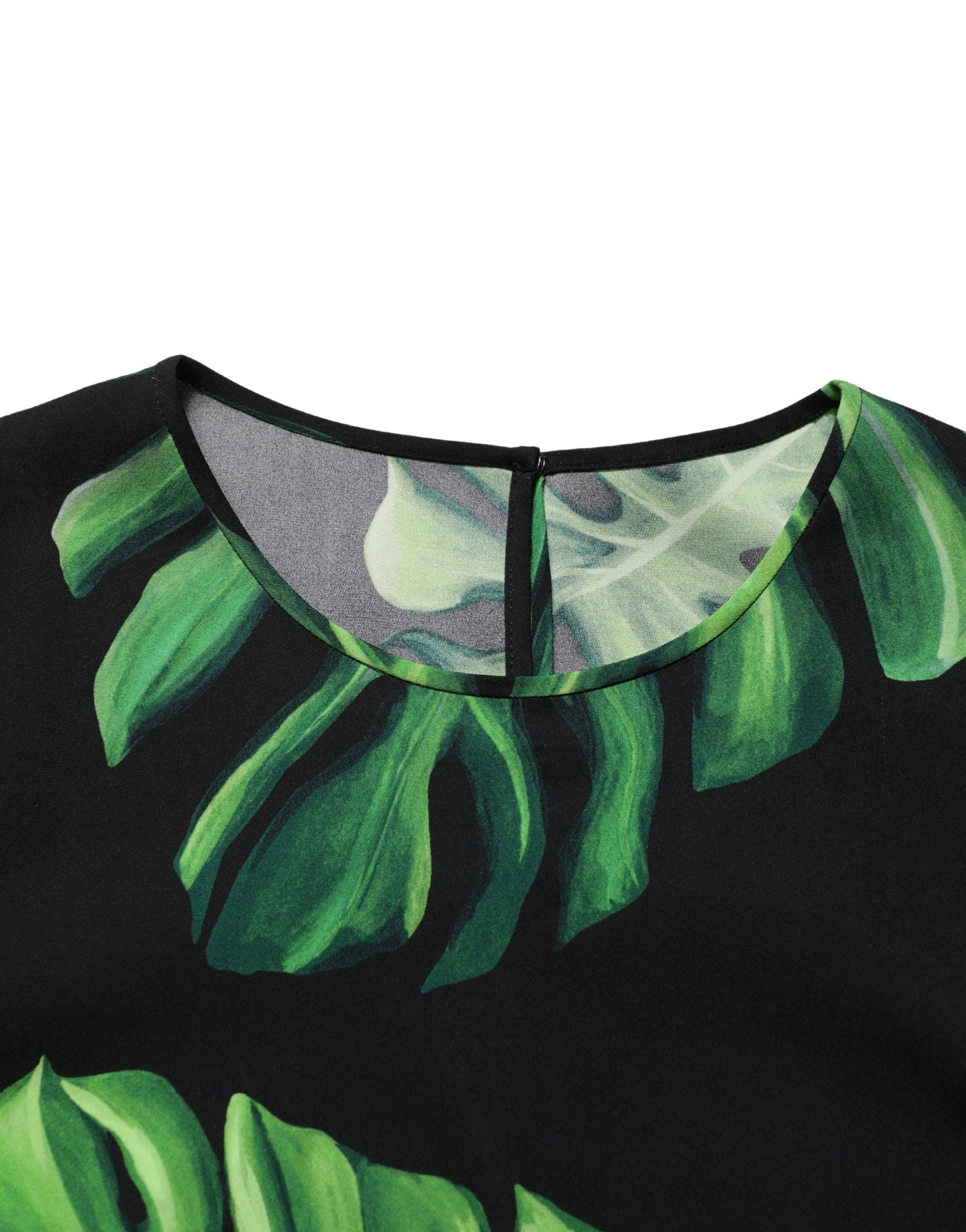 Blouse en soie noire Dolce & Gabbana avec motif de philodendron, manches longues et coupe élégante.
