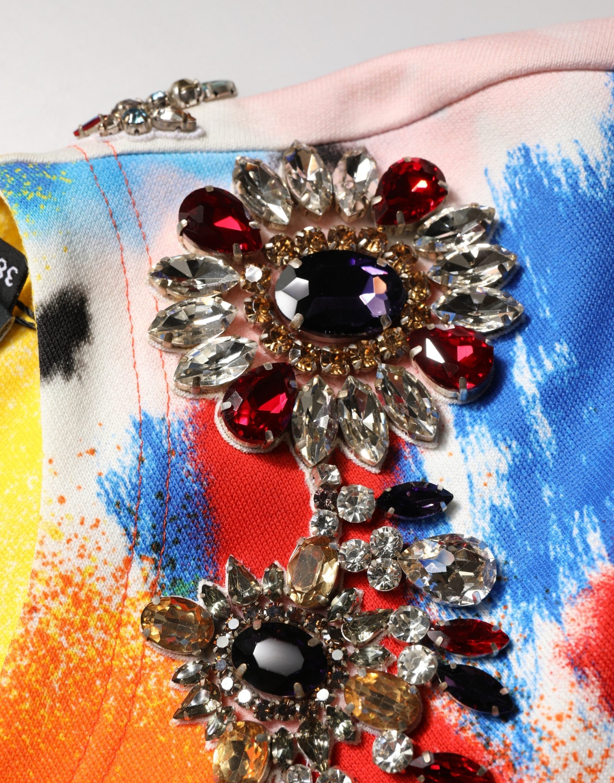 Top crop en jersey Dolce & Gabbana avec graffiti multicolore et cristaux, style tendance et vibrant.