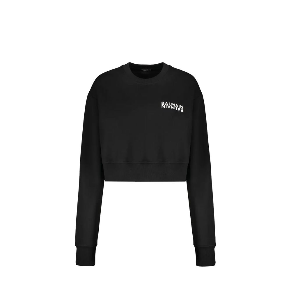 Sweatshirt en coton noir de Balmain, style décontracté avec logo discret, porté sur un mannequin.