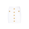 Jupe courte en polyester blanche de la marque Balmain, coupe ajustée, portée avec détails élégants et modernes.