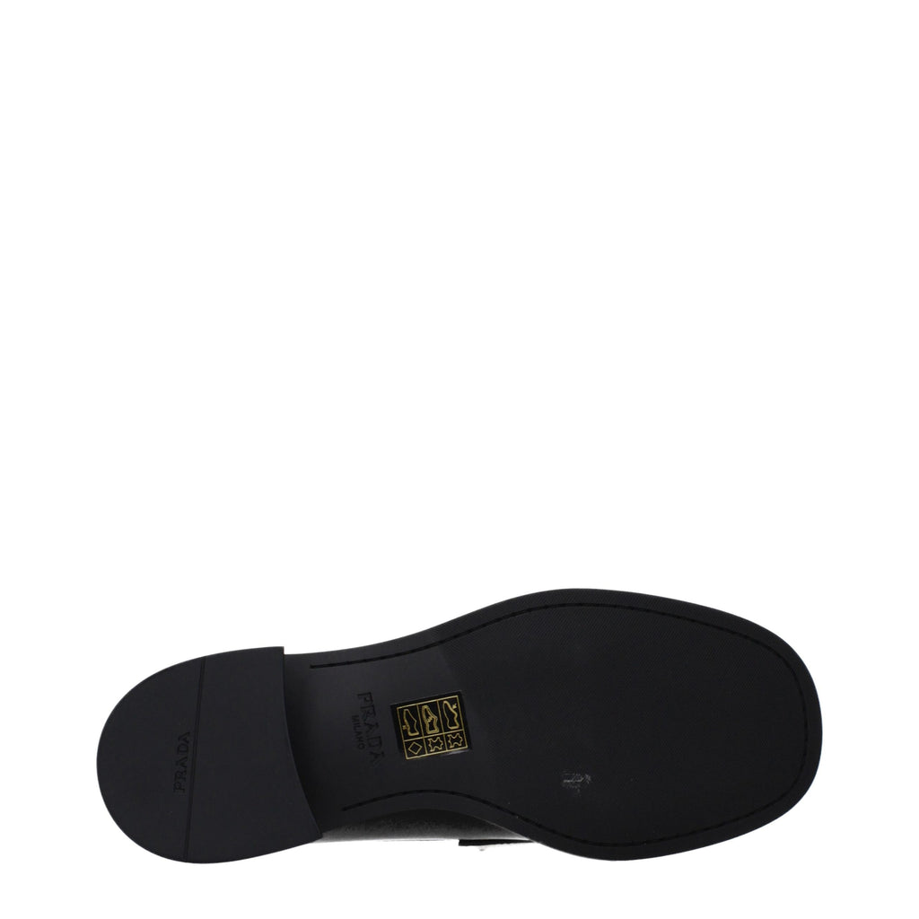 Mocassins en cuir noir Prada pour homme, chaussures slip-on élégantes et confortables, visibles de face avec coutures soignées.