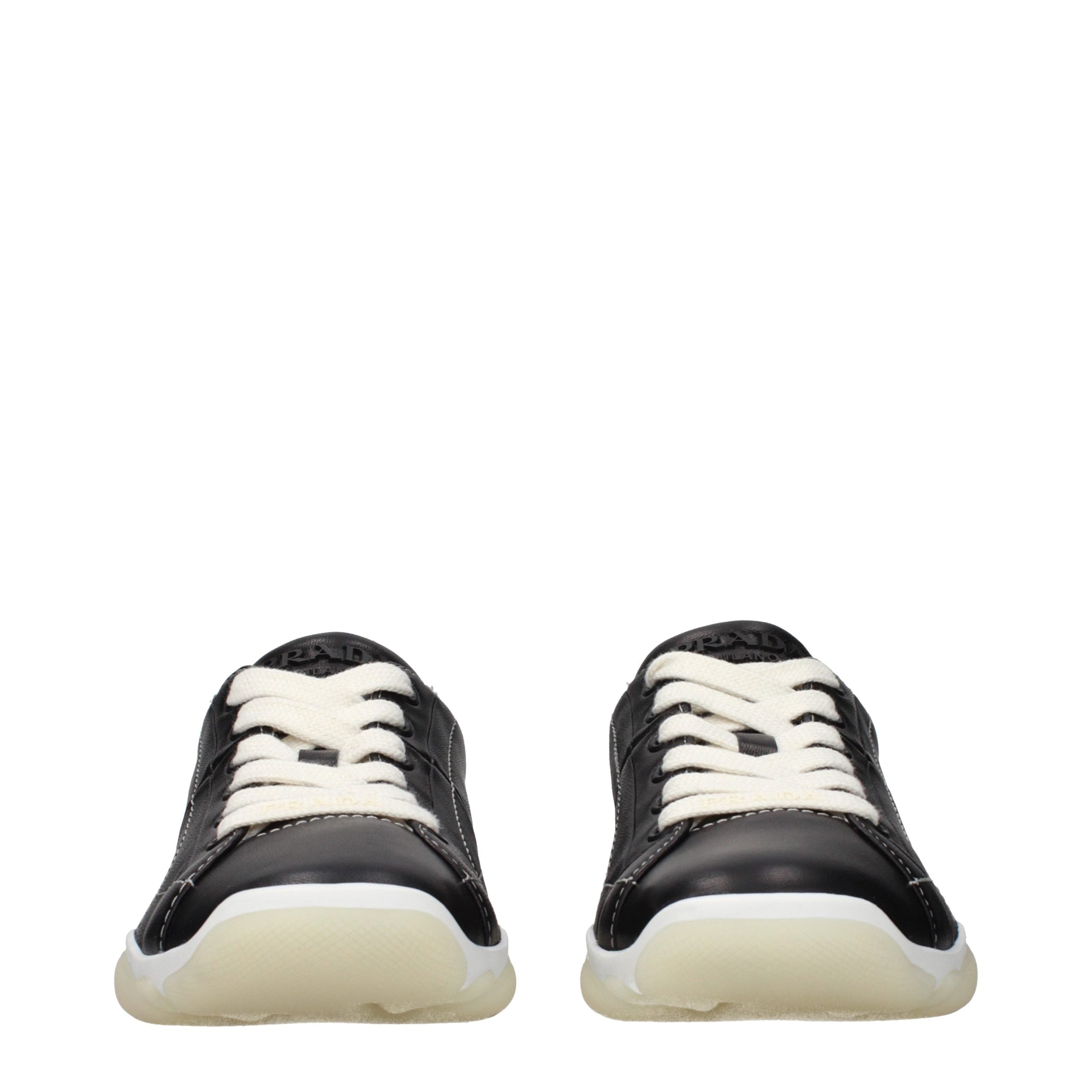 Chaussures sneakers en cuir noir Prada pour hommes, style moderne et élégant, visibles de face avec semelle blanche.