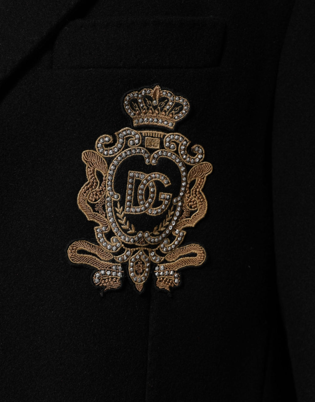 Veste blazer Dolce & Gabbana noire avec patch héraldique, à simple boutonnage, détail élégant et mode masculine sophistiquée.