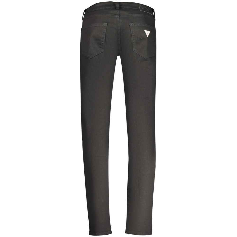 Jeans homme Guess en coton noir, style décontracté, coupe classique, porté avec une ceinture en denim.
