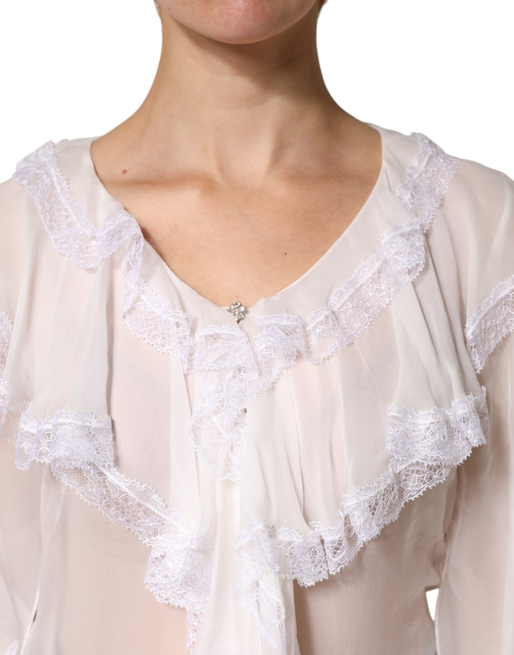 Chemisier blanc Dolce & Gabbana à manches longues, détails en dentelle et volants, élégant et féminin.