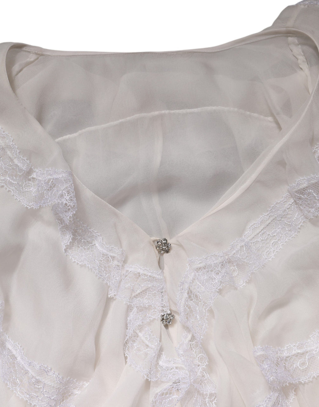 Blouse blanche Dolce & Gabbana à manches longues avec dentelle, volants et détails raffinés.