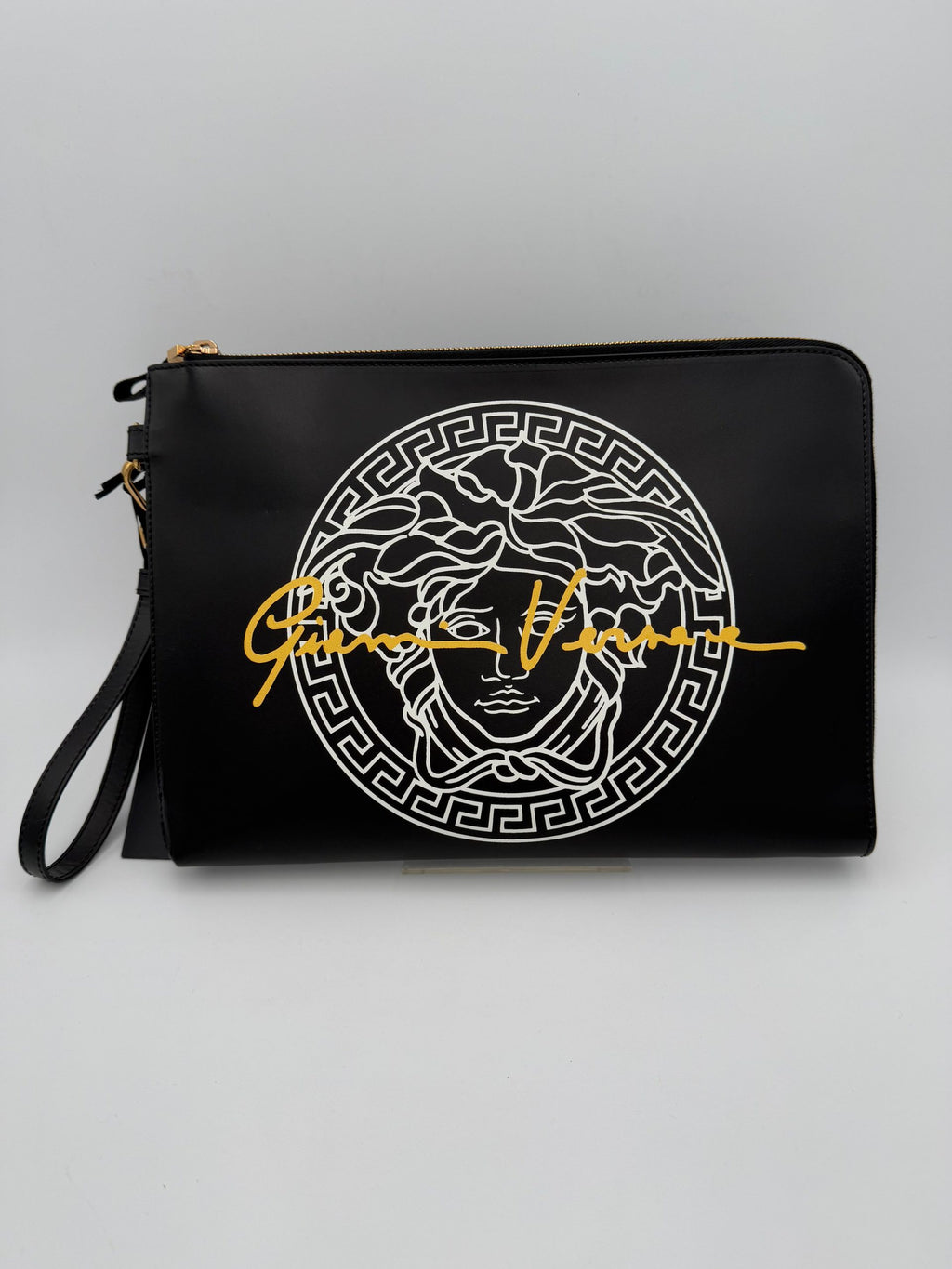 Clutch en cuir signature Versace La Medusa, élégante et sophistiquée, avec logo emblématique en or sur le devant.
